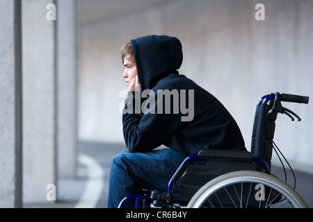 Österreich, Mondsee, junger Mann sitzt im Rollstuhl an der u-Bahn Stockfoto