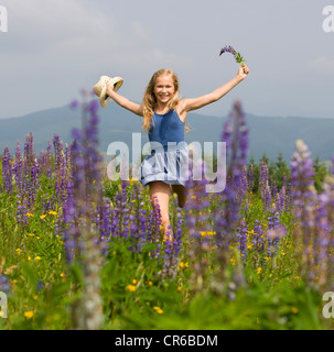 Österreich, Teenage Mädchen laufen in lupine Feld, Lächeln, Porträt Stockfoto