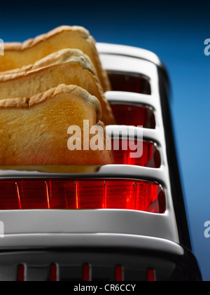 Toast im Toaster auf blauem Hintergrund Stockfoto