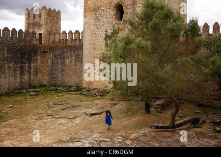 Eine Frau trägt ein blaues Kleid betritt die Aguzaderas Burg, El Coronil, Provinz Sevilla, Andalusien, Spanien, 17. April 2012. Stockfoto