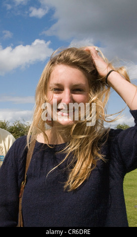 Model Release junge blonde Mädchen Porträt Lächeln halten Haare im Wind im freien Stockfoto