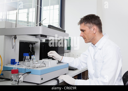 Deutschland, Bayern, München, Wissenschaftler analysieren Reagenzgläser mit Roboter-Geräte im Labor Stockfoto