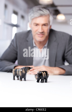 Deutschland, Bayern, München, reifer Mann Bulle und Bär Figuren betrachten Stockfoto