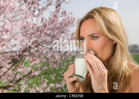 Deutschland, Nordrhein-Westfalen, junge Frau mit Glas Milch Stockfoto