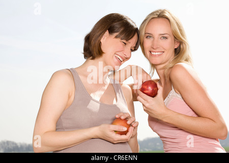 Deutschland, Nordrhein-Westfalen, Frauen mit Äpfeln, Lächeln Stockfoto