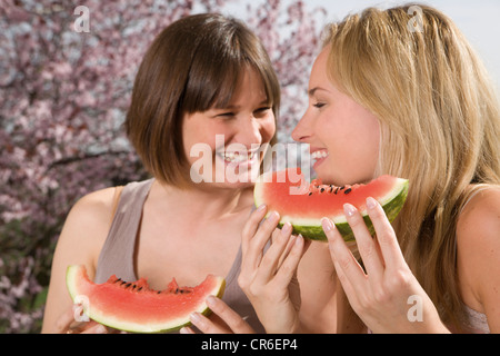 Deutschland, Nordrhein-Westfalen, Frauen Essen Wassermelone, Lächeln Stockfoto