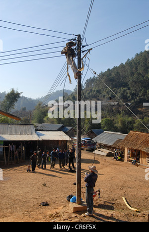 Laos, Hmong Dorf Nam Kha, Dorf Elektrifizierung von Lao-deutsche Firma Sunlabob und NGO, Arbeiter in der Energie Pfosten für die Verdrahtung eines off-grid-elektrisches Netz, die Energie kommt aus kleinen Wasserturbine Stockfoto