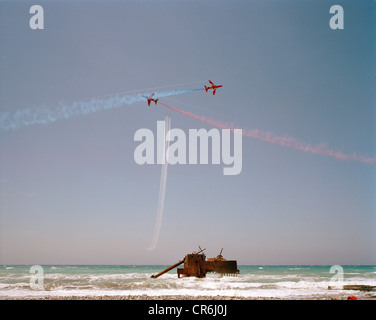 Hawk jets von der Red Arrows, die britische RAF aerobatic Team Praxis anzeigen mit einem alten Schiffswrack als Anzeige Datum (Mitte). Stockfoto