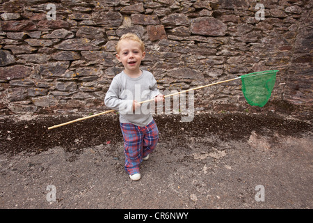 Zwei Jahre alten Jungen spielen mit einem Dip Net, Devon, England, Vereinigtes Königreich. Stockfoto