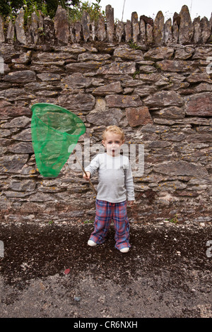 Zwei Jahre alten Jungen spielen mit einem Dip Net, Devon, England, Vereinigtes Königreich. Stockfoto