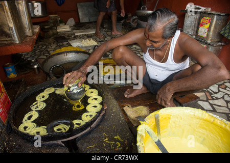 Mann Kochen gebratene Süßigkeiten in der Küche eine Konditorei, Fort Cochin, Kochi (Cochin), Kerala, Indien Stockfoto