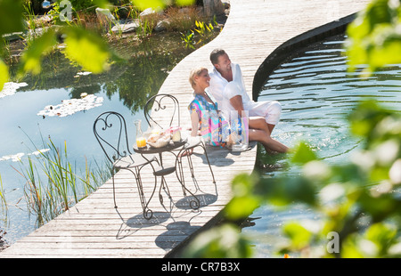 Österreich, Salzburger Land, paar frühstücken Sie auf Brücke über Teich Stockfoto