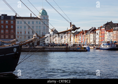 Blick auf den Nyhavn Kanal über den Hafen im Hafen von Kopenhagen durch die Rig und Bugspriet eines alten Segelschiff. Stockfoto