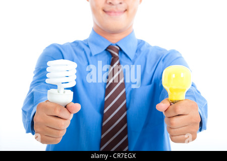 lächelnde Geschäftsmann hält energiesparende Glühbirne und Tradition Glühbirne Stockfoto