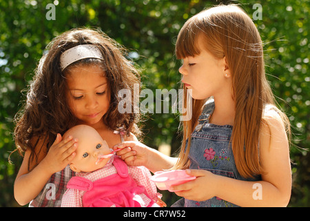 Kleine Mädchen eine Puppe füttern Stockfoto