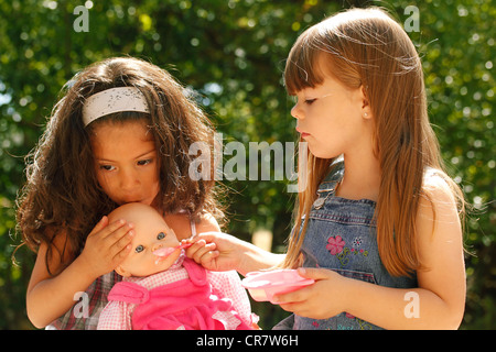 Kleine Mädchen eine Puppe füttern Stockfoto