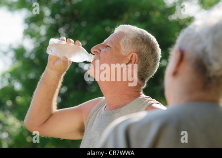 Senioren, alten Mann und Frau sprechen und trinken Wasser nach dem Training im park Stockfoto