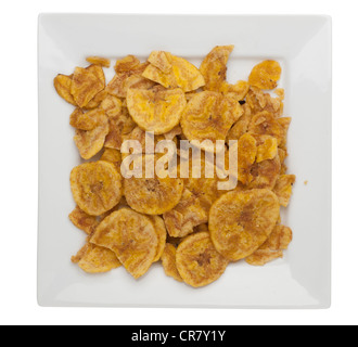 Haufen von Kochbananen Chips mit Meersalz auf weißen quadratischen Snack Platte Stockfoto