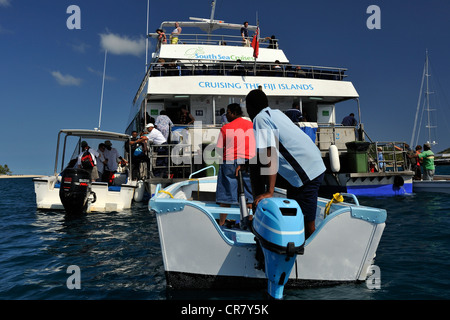 Kleine Boote mit der lokalen Bevölkerung und Gäste kommen neben Yasawa Flyer Die gestoppt hat, und driftet in der Blauen Lagune. Yasawa Islands, Fidschi, Stockfoto