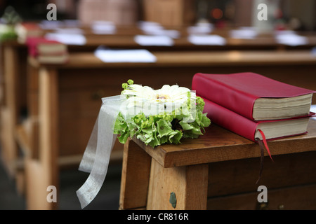 Florale Gestaltung und Gebet Gesangbücher, Dekorationen in einer Kirche für eine kirchliche Trauung Stockfoto