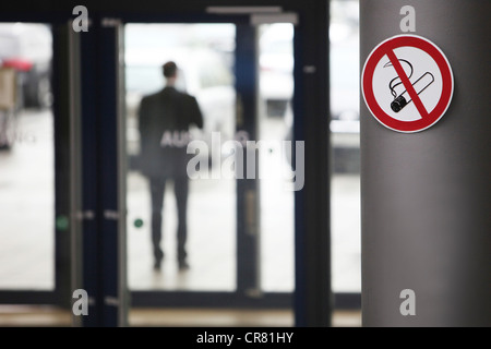 Kein Rauchen Zeichen und ein Mann vor einem Bürogebäude Rauchen Stockfoto