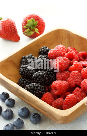 Verschiedene frische Beeren in Holzschale Stockfoto