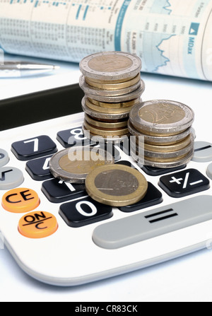 Taschenrechner mit Euro-Münzen, Kugelschreiber und Aktienmarkt Bericht auf weißem Hintergrund Stockfoto