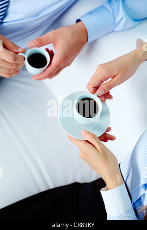 Nahaufnahme von zwei Geschäftspartnern Hände halten Tassen Kaffee Stockfoto