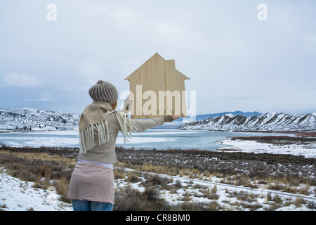 Frau in der malerischen Landschaft mit hölzernen Form eines Hauses Stockfoto