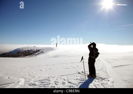 Langläufer genießen die Aussicht vom Gipfel des Feldbergs in Richtung Seebuck Berge im Nebel, Schwarzwald Stockfoto