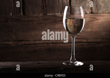 Ein Glas Weißwein vor einer rustikalen hölzernen Wand Stockfoto