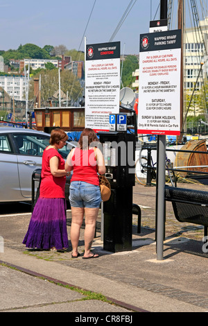 Zwei Frauen, die Beschickung der Maschine Parkplatz bezahlen und anzeigen ist die Norm in Bristol Stockfoto