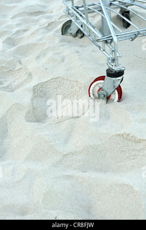 Rad der Einkaufswagen in tiefen Strandsand stecken Stockfoto