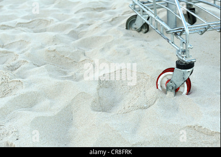 Rad der Einkaufswagen in tiefen Strandsand stecken Stockfoto
