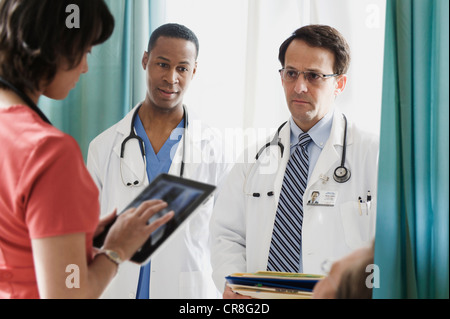 Ärzte in Diskussion mit Krankenschwester im Krankenhaus Stockfoto