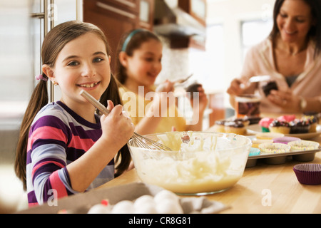 Porträt eines Mädchens, die Herstellung von Kuchen mit der Familie in Küche Stockfoto