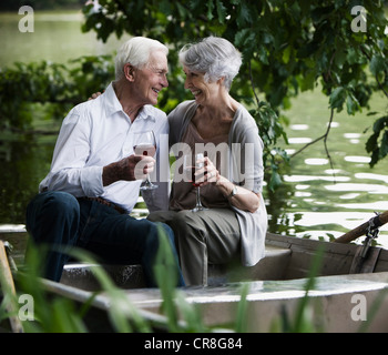 Älteres paar Weintrinken auf Ruderboot Stockfoto