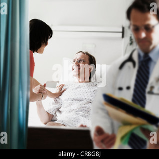 Arzt und Krankenschwester, die Kontrolle über Patienten im Krankenhausbett Stockfoto