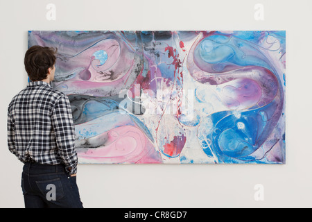 Junger Mann, Blick auf Ölgemälde in Galerie Stockfoto