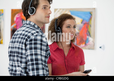 Junges Paar mit audio-Guides in Kunstgalerie Stockfoto