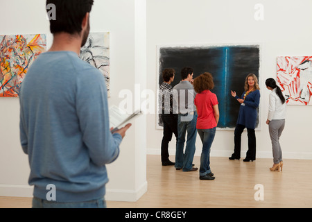 Männer und Frauen, die zuhören, um in der Art Gallery guide Stockfoto