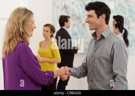 Hände schütteln Mitte erwachsenen Mann und Frau in der Art gallery Stockfoto