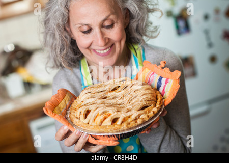 Ältere Frau mit frisch gebackenem Kuchen Stockfoto