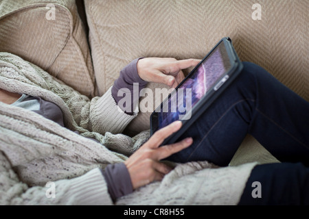 Ältere Frau mit digitalen Laptop auf Sofa, Mittelteil Stockfoto