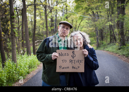 Älteres Paar mit Schild im Wald, Porträt Stockfoto