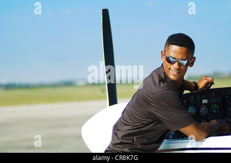 Ein Pilot überprüft sein Flugzeug vor dem Start Pausen über seine Schulter mit zusammengebissenen Zähnen schauen. Stockfoto