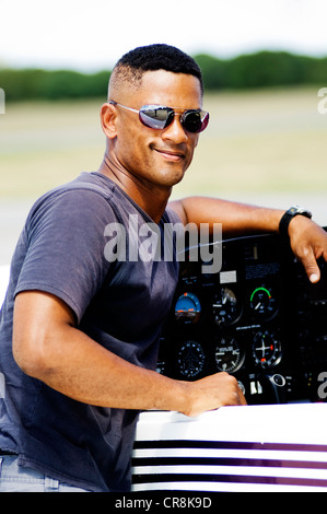 Ein Pilot überprüft sein Flugzeug vor dem Start Pausen für ein Porträt. Stockfoto