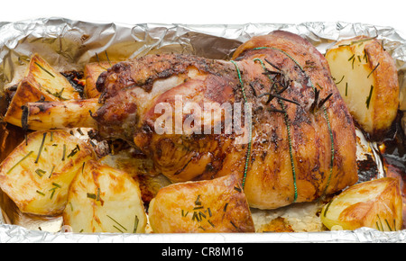 Gebratene Lammkeule mit Röstkartoffeln aus dem Backofen in einer Auflaufform genommen. Stockfoto