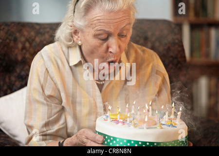 Ältere Frau Geburtstagskerzen Ausblasen Stockfoto