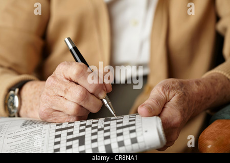 Ältere Frau macht Kreuzworträtsel Stockfoto